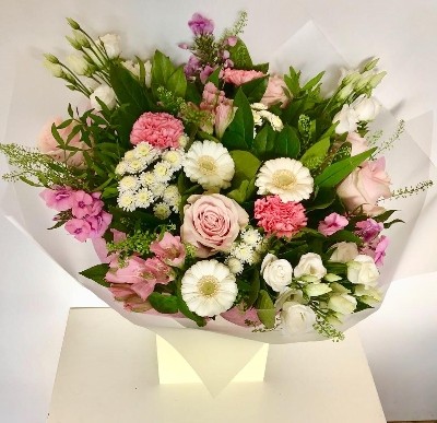 Natural hand tied bouquet in soft tones including roses, germini, lizianthus and chrysanthemums.