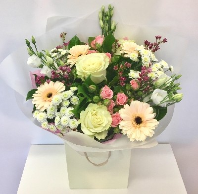 Floral favourites including roses, wax flower, germini and lisianthus in soft tones. 