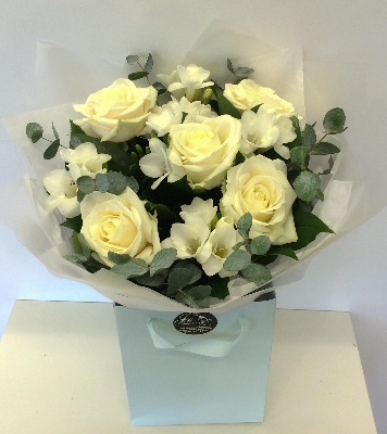 White rose and freesia bouquet finished with a touch of glitter. 