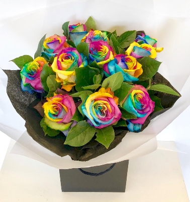 Luxury rainbow roses hand tied in water wrapped in our signature black cellophane and bag. 