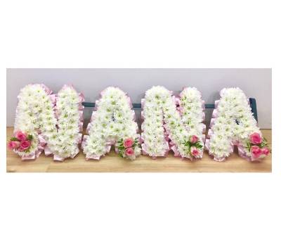 Ribbon edged NANA funeral tribute with pale pink rose focal. 
