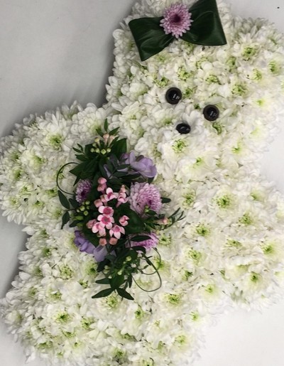 Girly teddy bear funeral tribute created with chrysanthemum and finished with hair bow and focals. 