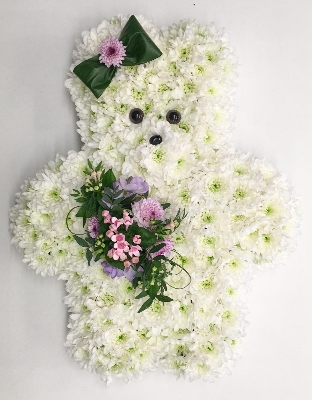Girly teddy bear funeral tribute created with chrysanthemum and finished with hair bow and focals. 