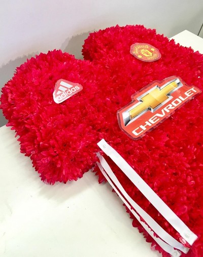 Manchester United football shirt funeral tribute created with chrysanthemum and waterproof badges and logos. 