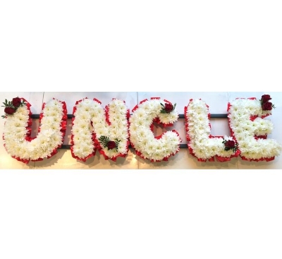 UNCLE Funeral lettering tribute with massed white chrysanthemum and red focal and ribbon edge. 