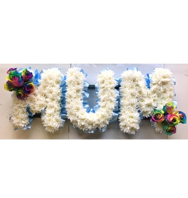 Rainbow focal MUM funeral tribute with white chrysanthemum base. 