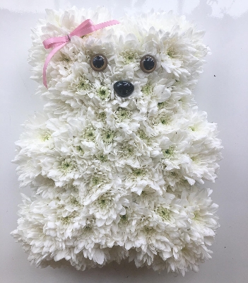 Tiny teddy bear funeral tribute created using white chrysanthemum and ribbon bow. 