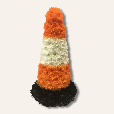 3D traffic cone-shaped funeral tribute made with neon orange and white sprayed chrysanthemums on a black base, measuring approximately 66cm high by 40cm wide.