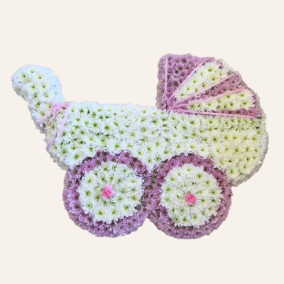 Pink pram-shaped funeral tribute made with white and pink sprayed chrysanthemum, finished with pipe cleaner and spray-painted detailing, measuring approximately 80cm x 60cm.