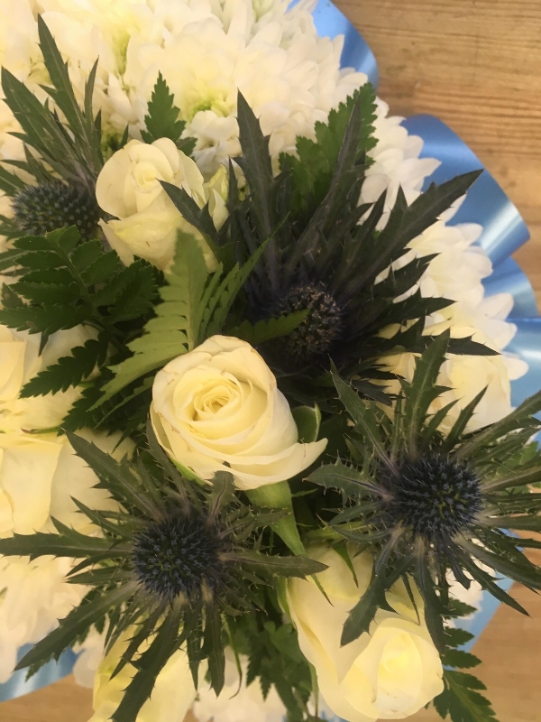 Blue heart funeral tribute with white rose and blue thistle focal. 