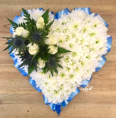Blue heart funeral tribute with white rose and blue thistle focal. 