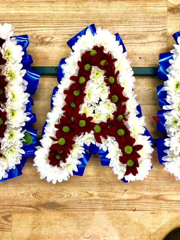 British themed funeral lettering created with mixed chrysanthemum and ribbon edge. 