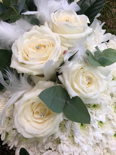 Beautiful dove funeral design with white chrysanthemum, white roses and feather detailing. 