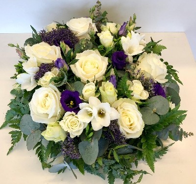 Violet and white funeral posy with mixed seasonal flowers and eucalyptus foliage for a fresh, natural finish