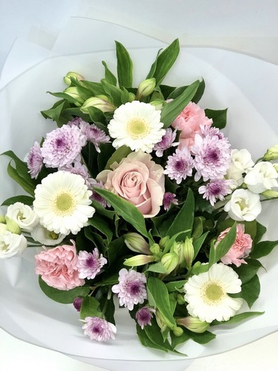 Hand tied bouquet of soft tones, includes roses, carnation, chrysanthemums and germini. 