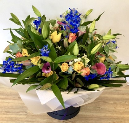 Luxury hand tied of lily, calla lily, delphinium and roses. 