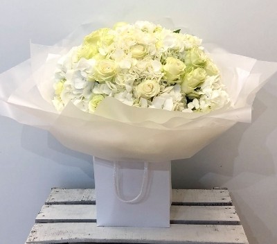 Luxury hand tied of white hydrangea and white roses. 