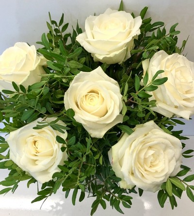 White rose bouquet displayed in a glass vase with zero plastic. 