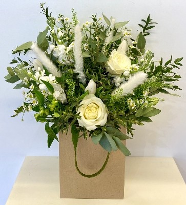 Natural hand tied bouquet in white tones including roses, stocks and pampas grass. 