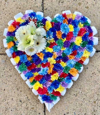 Beautiful speckled rainbow heart funeral tribute made with chrysanthemum and finished with a white ribbon edge and focal. 