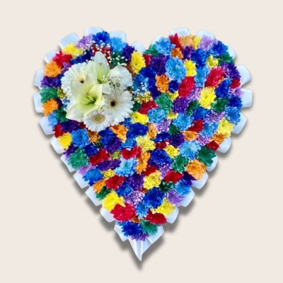 Beautiful speckled rainbow heart funeral tribute made with chrysanthemum and finished with a white ribbon edge and focal. 