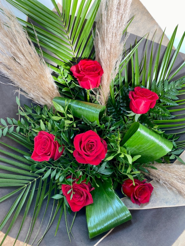 Luxury bouquet including stunning red roses and natural pampas grass, presented in craft paper and black gift bag. 