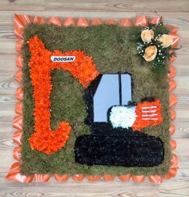 Doosan digger funeral tribute with vivid orange chrysanthemum on a moss board and finished with printed detailing. 