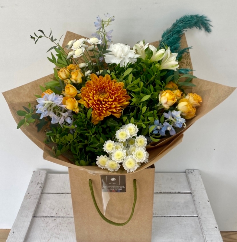 Sweater weather including rusty orange and rich teal colours. Spray rose, blooms, delphinium and pampas grass work perfectly together in this hand tied bouquet in water. 
