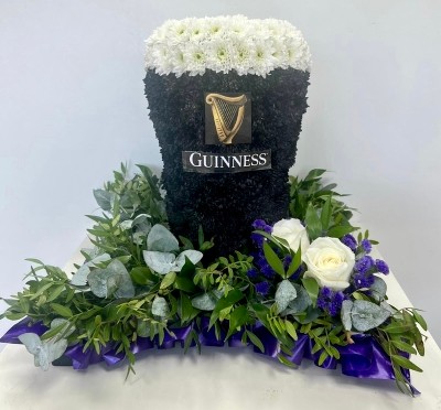 3D Guinness funeral tribute, created with sprayed chrysanthemum and mixed foliage cushion base. 
