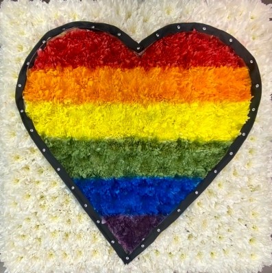 Pride flag funeral tribute in a heart shape with ribbon trim and diamante detailing. 