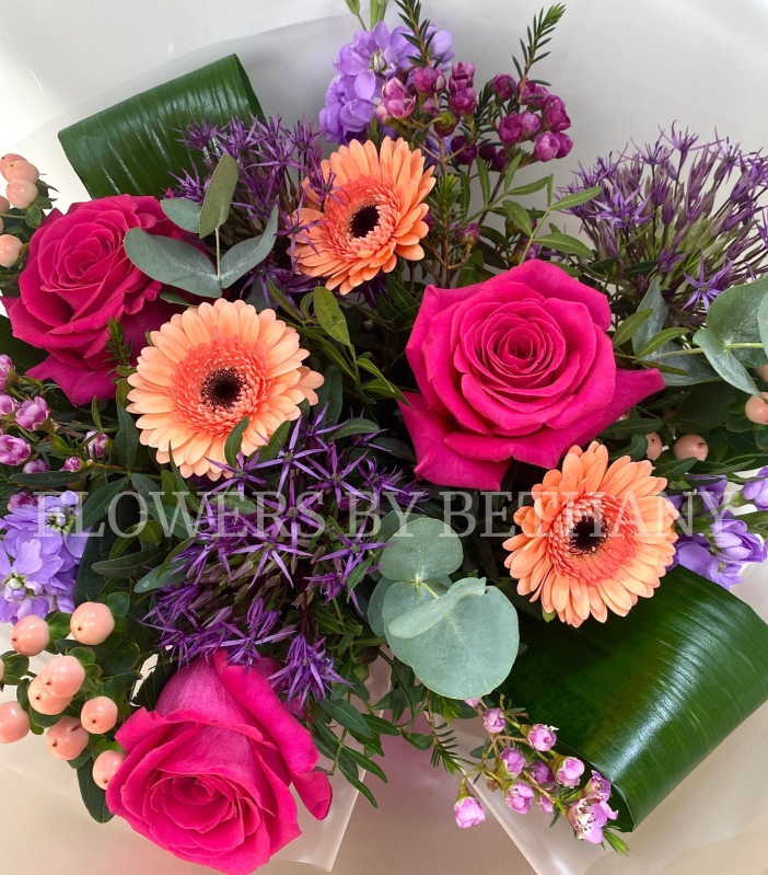 Peach and purple bouquet including allium, roses, germini, wax flower, stocks and more. Hand tied in water and presented in a gift bag. 