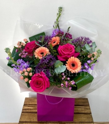 Peach and purple bouquet including allium, roses, germini, wax flower, stocks and more. Hand tied in water and presented in a gift bag. 