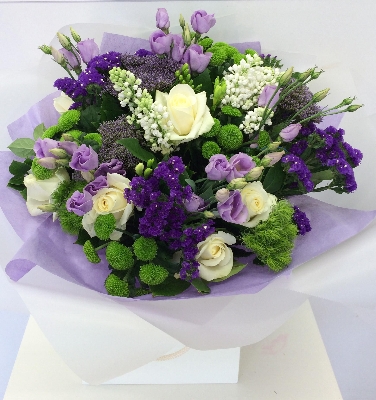 Hand tied bouquet including white rose, purple static, lilac lizianthus and finished with scented freesia. 