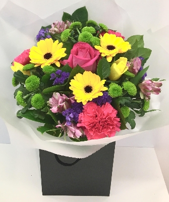 Bright and beautiful bouquet including pink roses, yellow tulips, purple statice and green kermit chrysanthemums. 