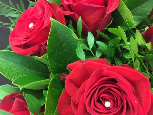 12 Luxury red roses with diamanté centre and complementary foliage presented in a matte black hat box. 