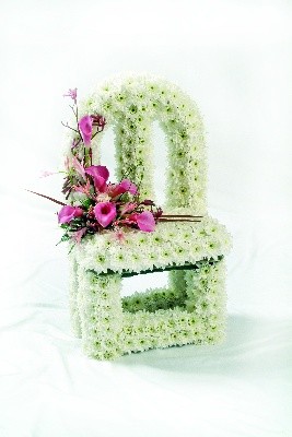 Vacant chair funeral tribute with lovely soft pink focal flowers. 