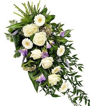 White rose and lilac freesia funeral spray with veronica, germini, and greenery.