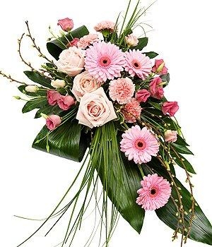 Pink single-ended funeral spray with seasonal flowers, grass, and aspidistra foliage.