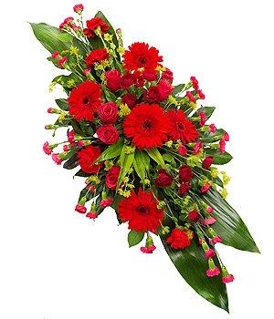 Red double-ended casket spray with seasonal florals and contrasting foliage.