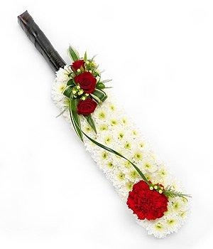 Cricket bat funeral tribute with red rose and carnations focal. 