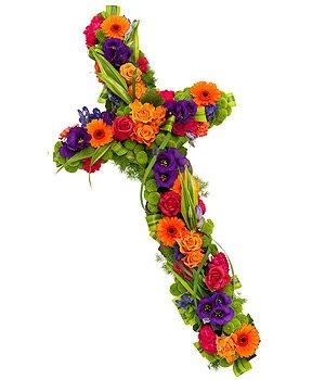 Vibrant floral cross with orange, purple, green, pink, and red seasonal florals and mixed foliage.