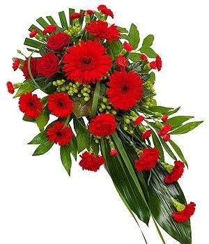Red single-ended funeral spray with seasonal flowers and green foliage.