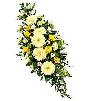 Double-ended funeral spray with yellow seasonal florals and green foliage.