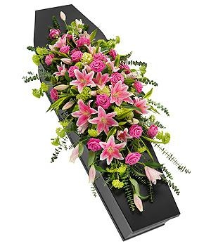 Vivid pink rose and lily casket spray with hydrangea, viburnum, eucalyptus, and variegated lime dracaena leaves.
