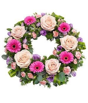 Mixed pink toned funeral wreath including roses, germini and carnations with touches of lilac lisianthus to contrast. 
