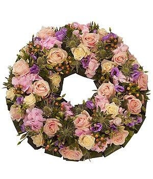 Luxury pastel mixed funeral wreath including roses, lisianthus and thistle. 