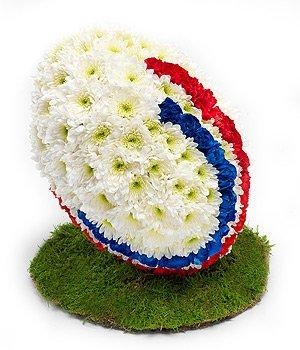 3D Rugby ball funeral tribute made with massed chrysanthemum on a turf effect base. 