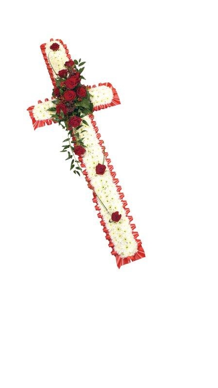 White chrysanthemum cross with red ribbon edge, red rose spray, and lush foliage.