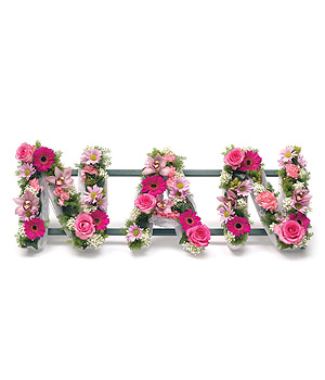 Loose pink NAN funeral tribute in mixed seasonal flowers. 