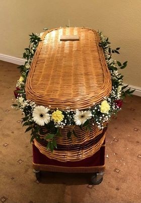 Delicate foliage and seasonal florals garland for wicker casket, customizable in colour and fullness.
